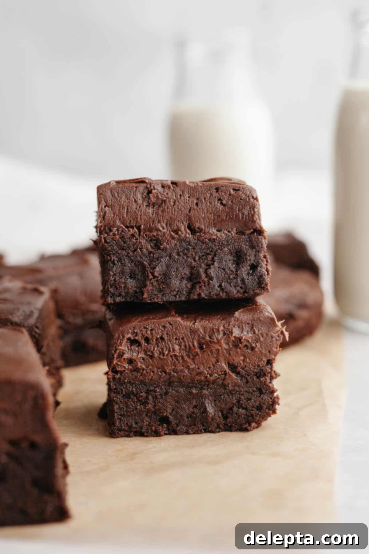 Rich Chocolate Brownies with Tangy Cream Cheese Frosting 10 A stack of two beautifully frosted brownies, showcasing the thick layer of chocolate cream cheese frosting.