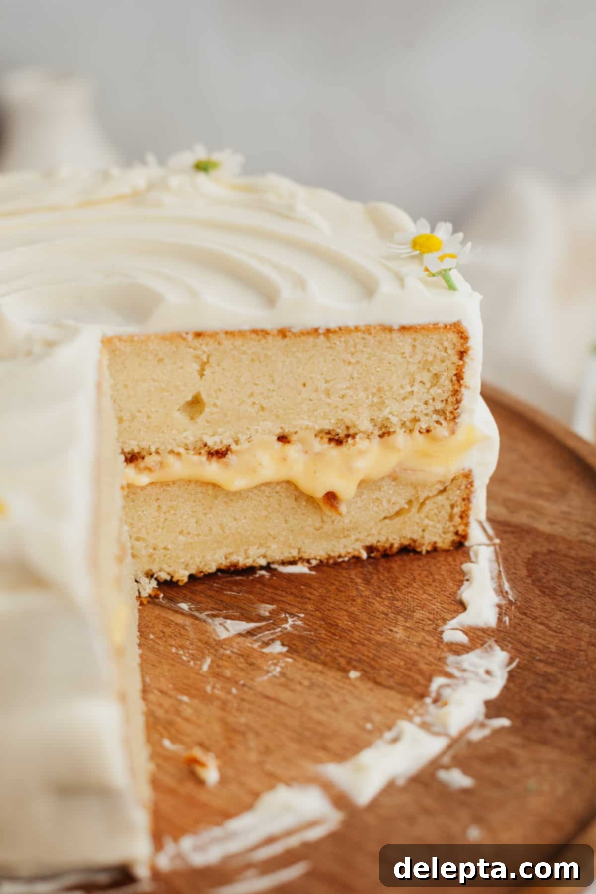 Zesty Lemon Curd Delight 12 A beautifully cut lemon curd cake on a rustic wooden cake stand, showcasing its inviting layers and delicious filling.