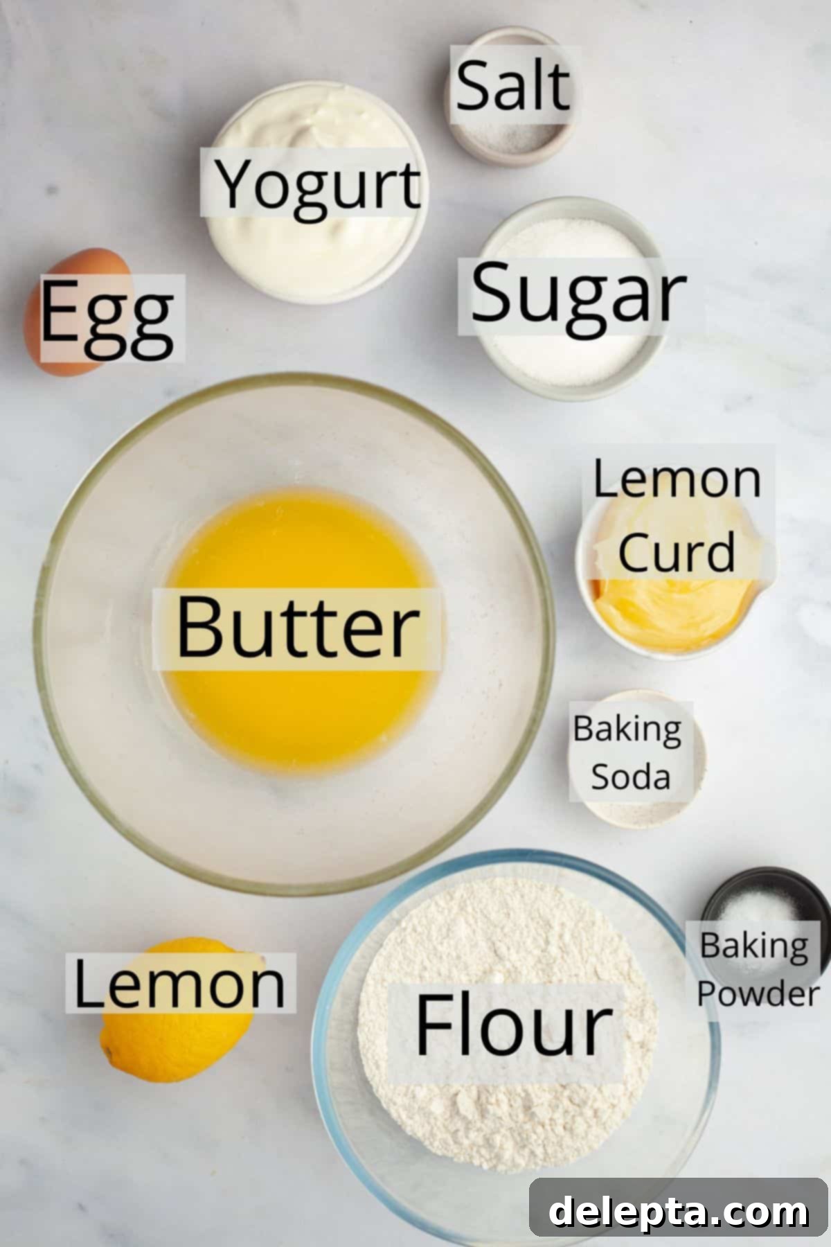 Tangy Lemon Swirl Muffins 3 All the ingredients needed to make lemon curd muffins weighed out into small bowls, including flour, sugar, lemon, butter, and yogurt.
