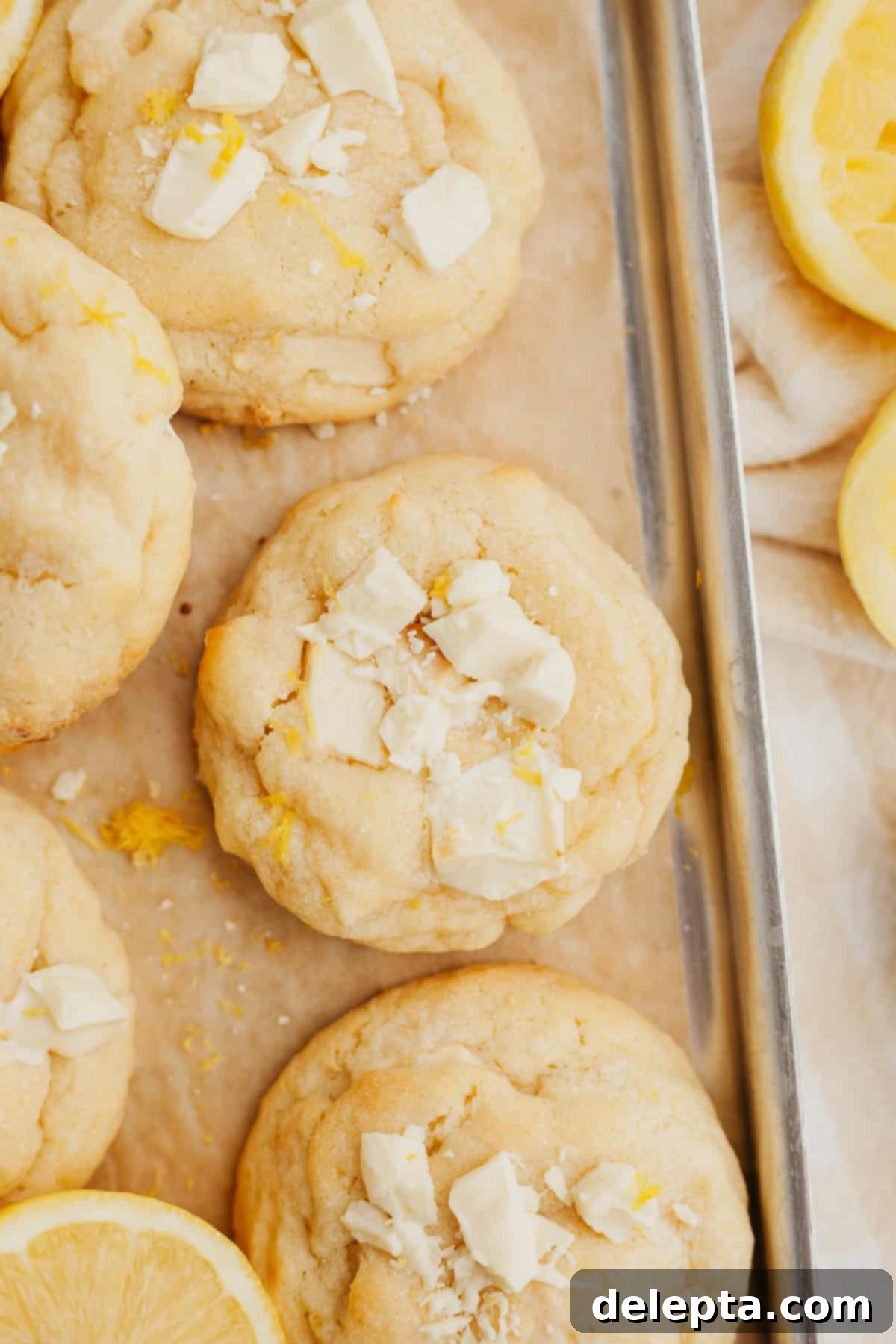 Sunshine Lemon White Chocolate Delights 8 A top-down view of beautifully arranged white chocolate lemon cookies on light brown parchment paper, showcasing their perfect shape and golden edges.