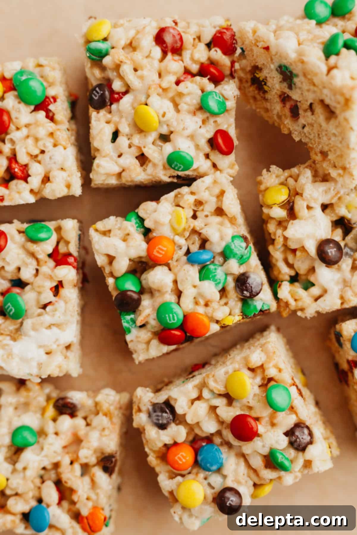 Colorful M and M Krispie Bars 2 Vibrant M&M Rice Krispie treats arranged neatly on parchment paper, showcasing their colorful chocolate candy additions.