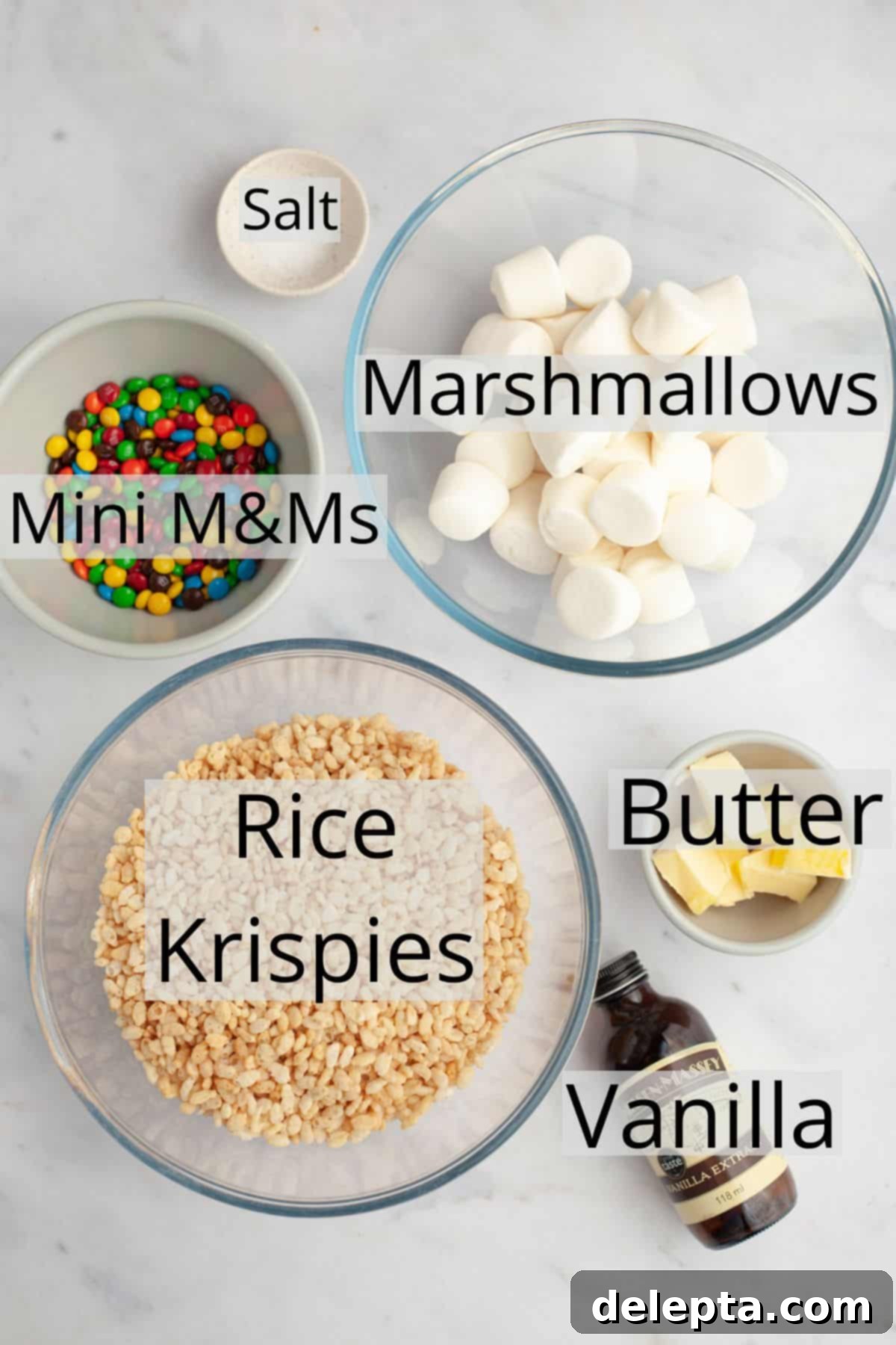 Colorful M and M Krispie Bars 3 All the key ingredients for M&M Rice Krispie treats, including cereal, butter, marshmallows, vanilla, salt, and M&Ms, neatly portioned in small bowls.
