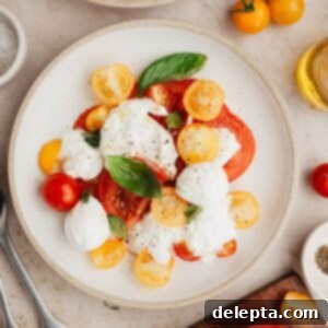 Fresh Burrata Caprese 6 A burrata caprese salad on a small plate.