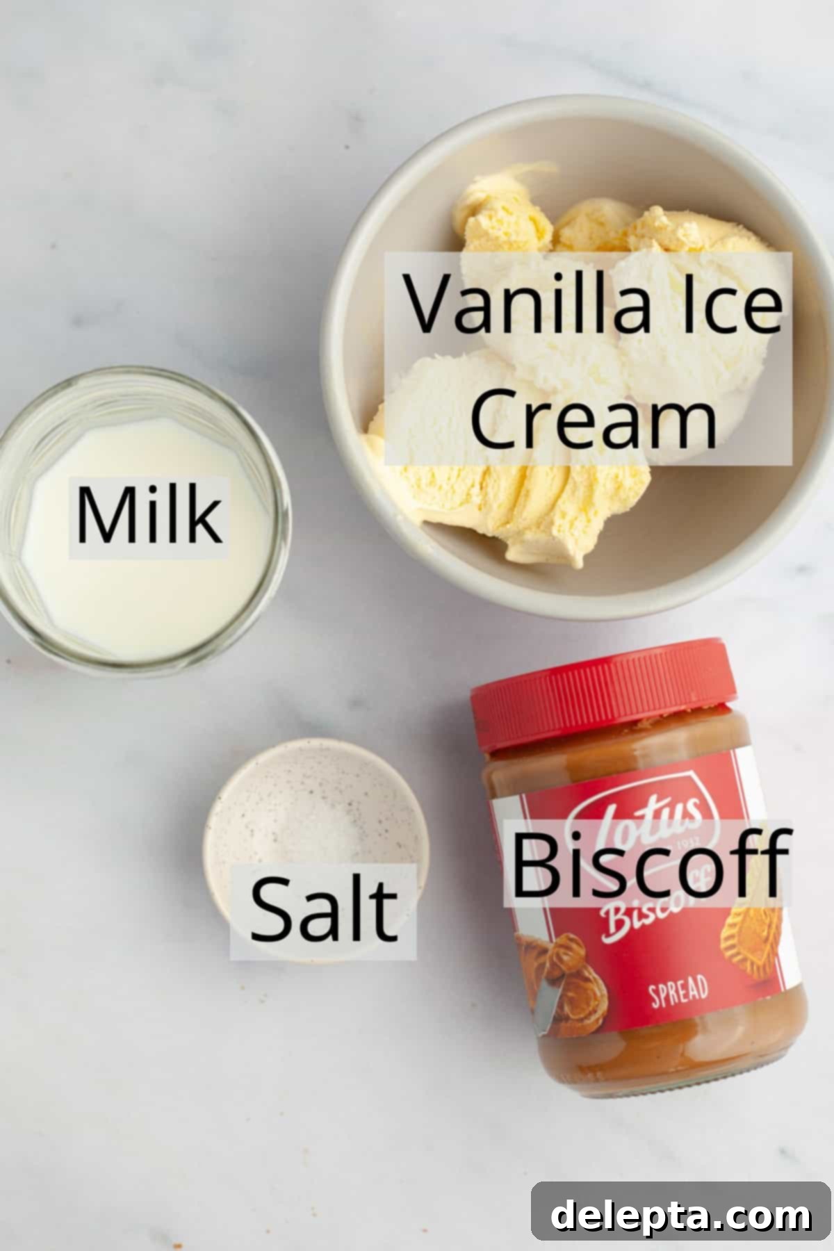 Creamy Biscoff Milkshake 3 All the ingredients needed to make a biscoff milkshake weighed out into small bowls, including vanilla ice cream, biscoff spread, milk, and a pinch of salt.