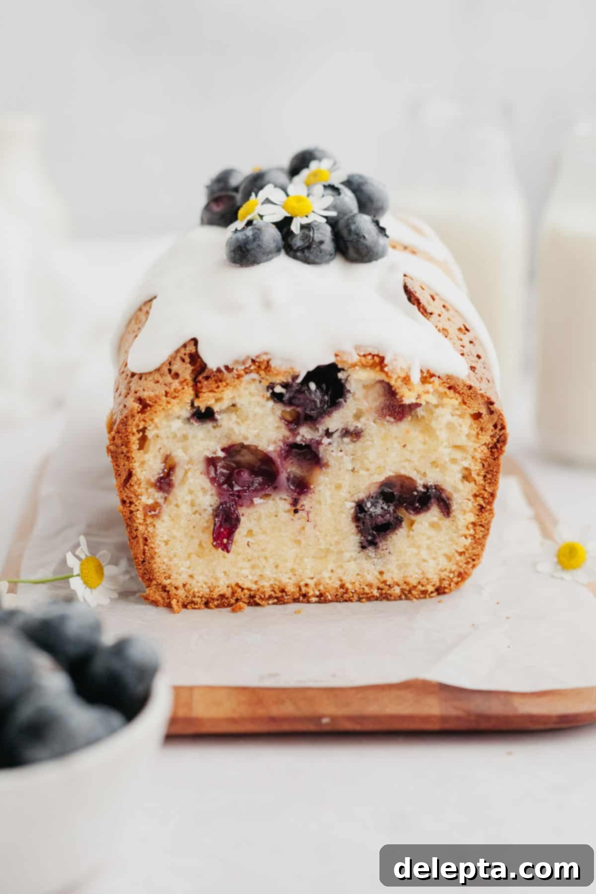 Heavenly Blueberry Pound Cake 2 A perfectly baked blueberry loaf cake, generously drizzled with a bright white lemon glaze and garnished with fresh blueberries on top.