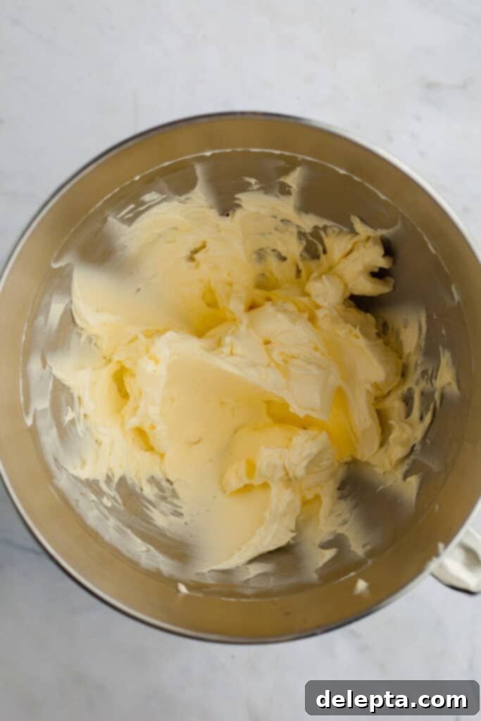 Ultimate Tiramisu Layer Cake 13 A metal mixing bowl with whipped butter and mascarpone