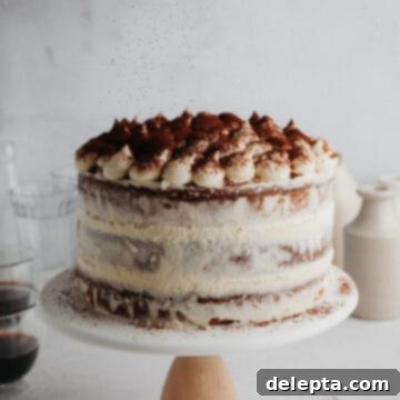 Ultimate Tiramisu Layer Cake 17 A tiramisu layer cake on a white cake stand