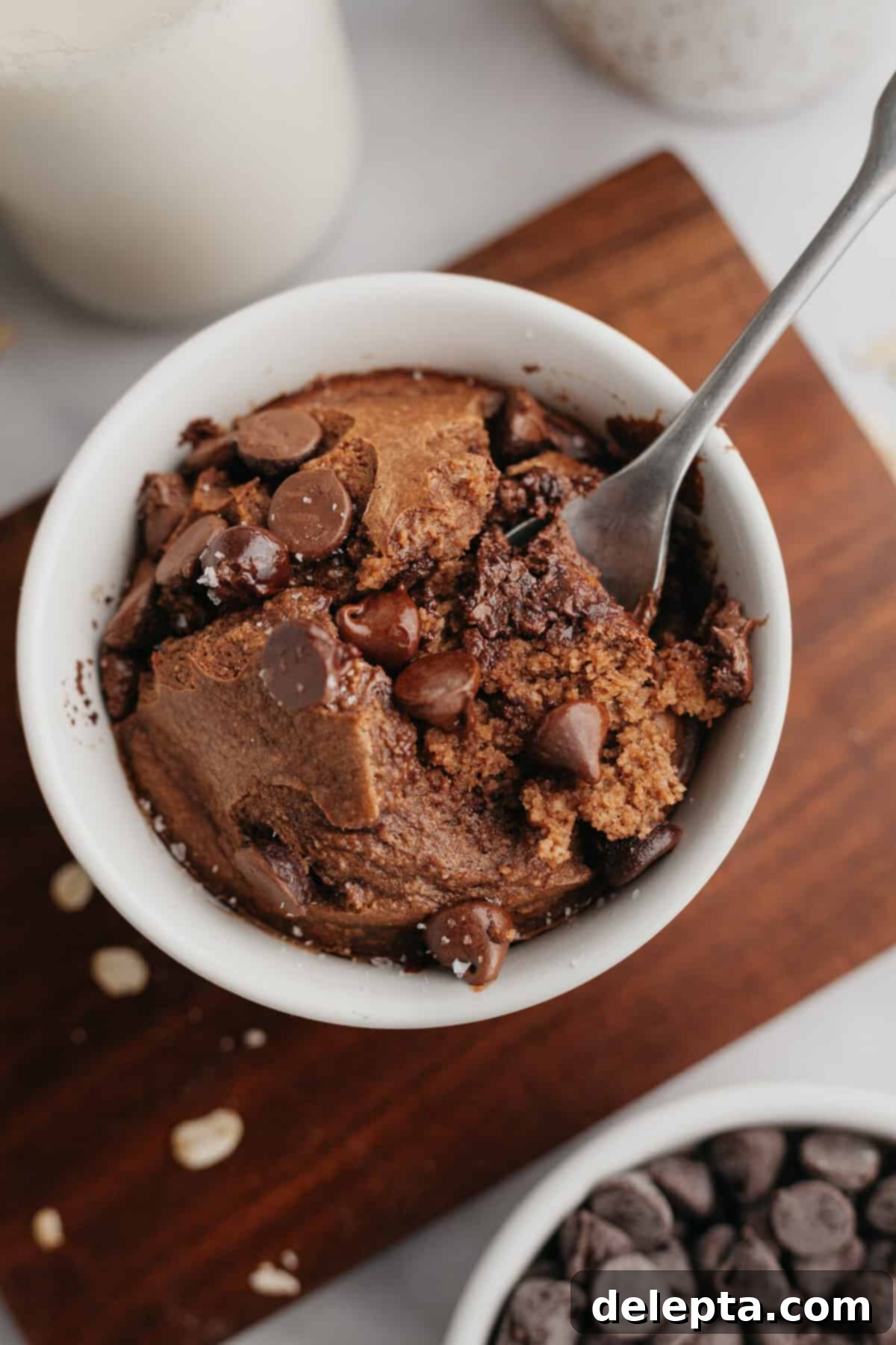 Decadent Chocolate Baked Oats 2 Rich chocolate baked oats served in a small white ramekin, topped with a few chocolate chips, ready to be enjoyed as a luxurious breakfast or dessert.
