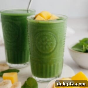 Vibrant Mango Spinach Smoothie 6 Two green smoothies in glasses, one has mango pieces on top, showcasing the final vibrant drink.