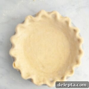 Perfectly Flaky Homemade Pie Crust 11 Unbaked pie dough in a pie pan, ready for its delicious filling.