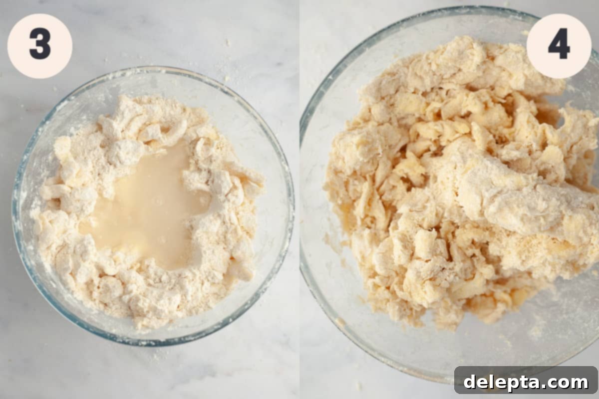 Perfectly Flaky Homemade Pie Crust 5 Shaggy pie dough in a large mixing bowl after adding ice water, showing distinct butter pieces.
