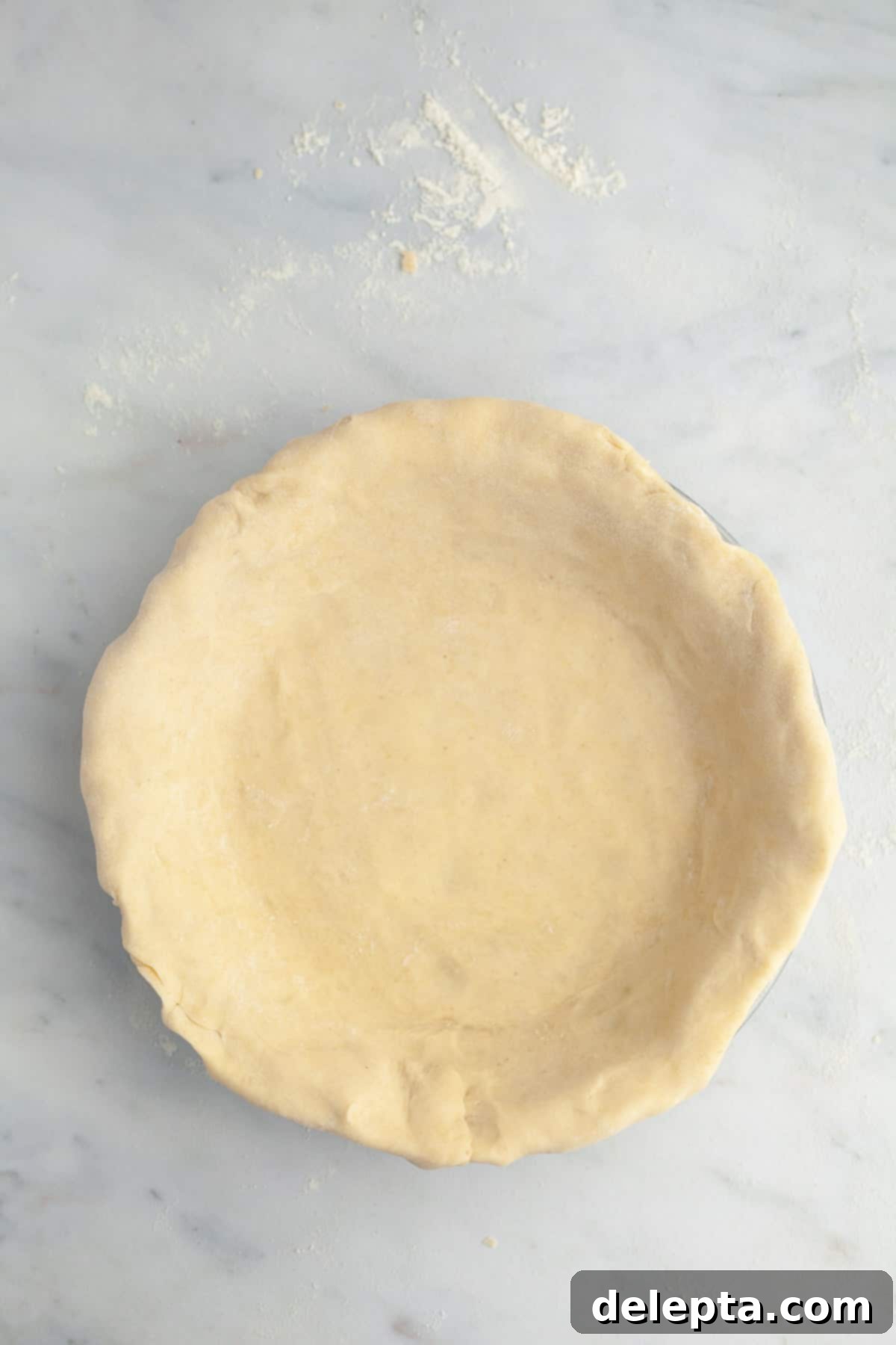 Perfectly Flaky Homemade Pie Crust 8 Unbaked pie dough beautifully crimped and settled in a pie plate, waiting for its delicious filling.