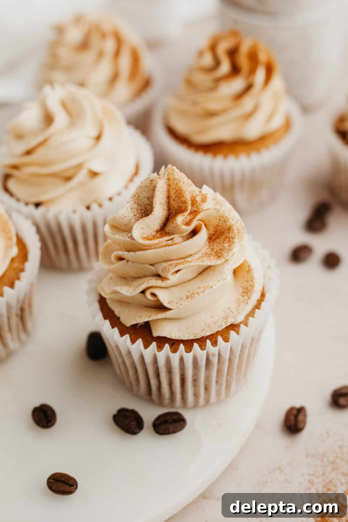 Java Velvet 5 A few espresso cupcakes with creamy coffee buttercream frosting, garnished with coffee beans, ready to be enjoyed.