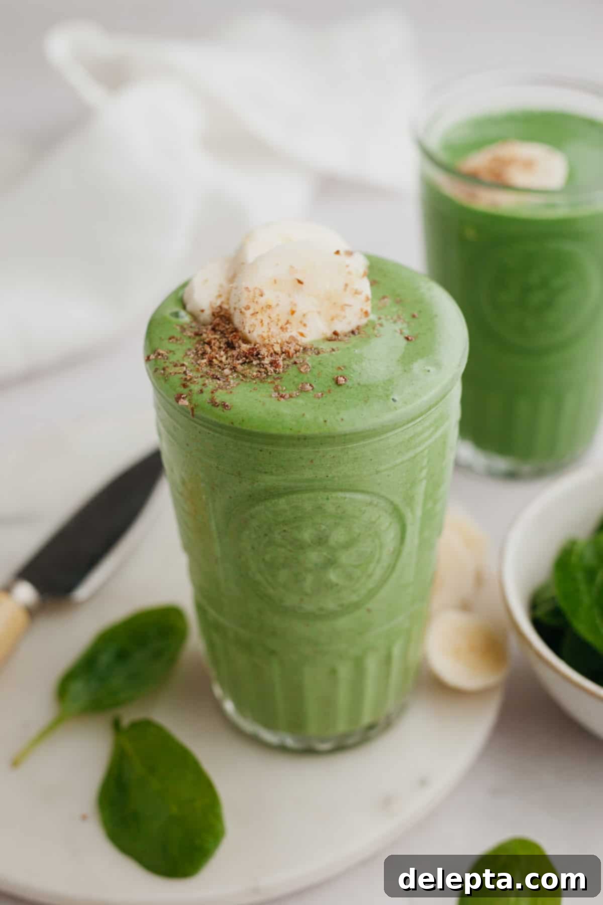 Green Velvet Revitalizer 2 A tall glass of a creamy green banana spinach smoothie, ready to be enjoyed.