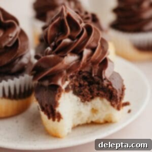 Sweet Harmony Cupcakes 10 A close up of a marbled cupcake with chocolate frosting, a bite has been taken out of the cupcake.