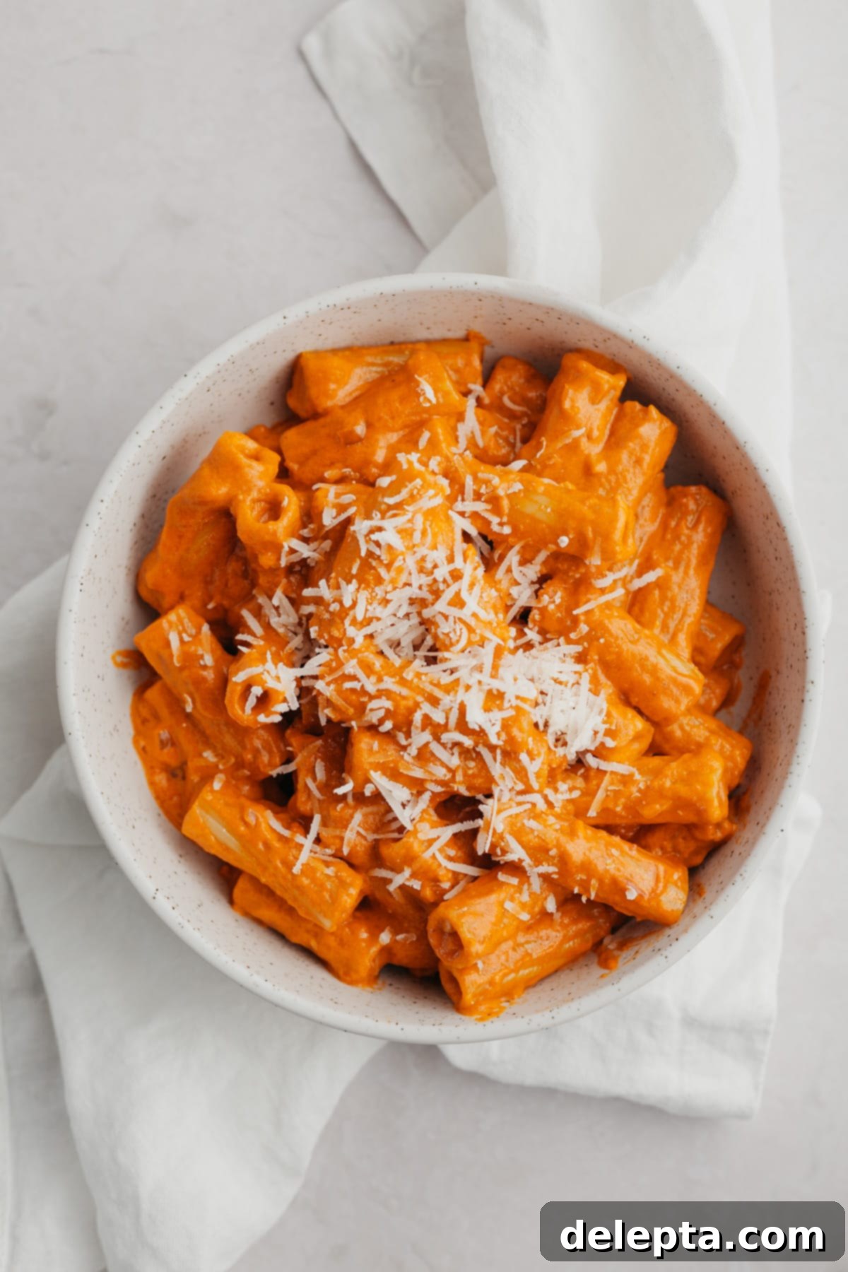 Viral Easy Spicy Vodka Pasta 7 A white bowl with vodka pasta in it garnished with extra parmesan.