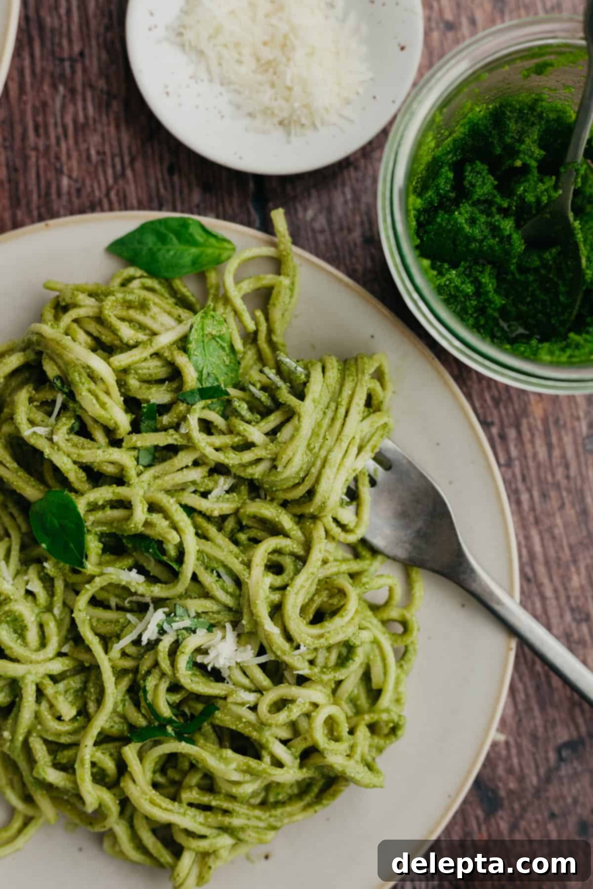 Homemade Pesto Pasta 7 A vibrant and appetizing plate of pesto pasta, garnished with fresh basil and grated cheese, ready to be enjoyed.