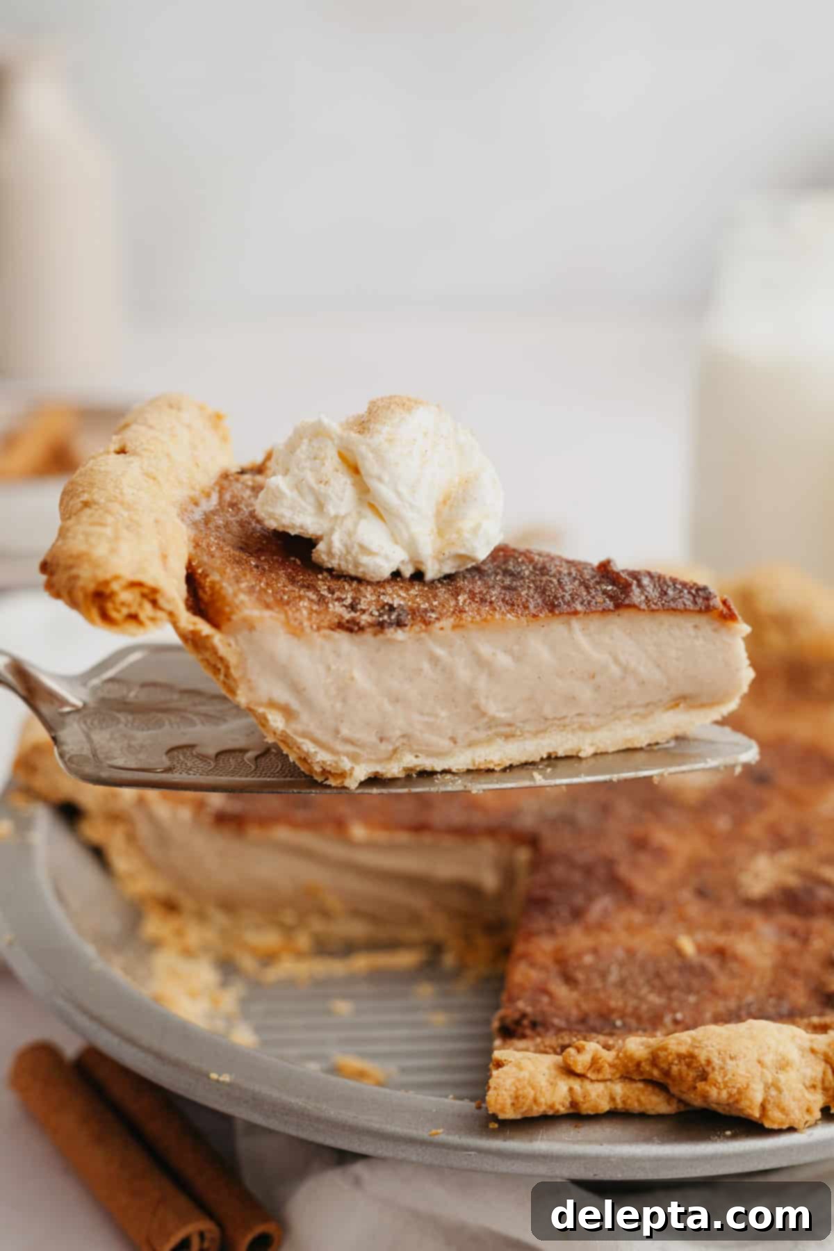 Effortless Cinnamon Pie 2 A silver cake serving lifting up a slice of pie.