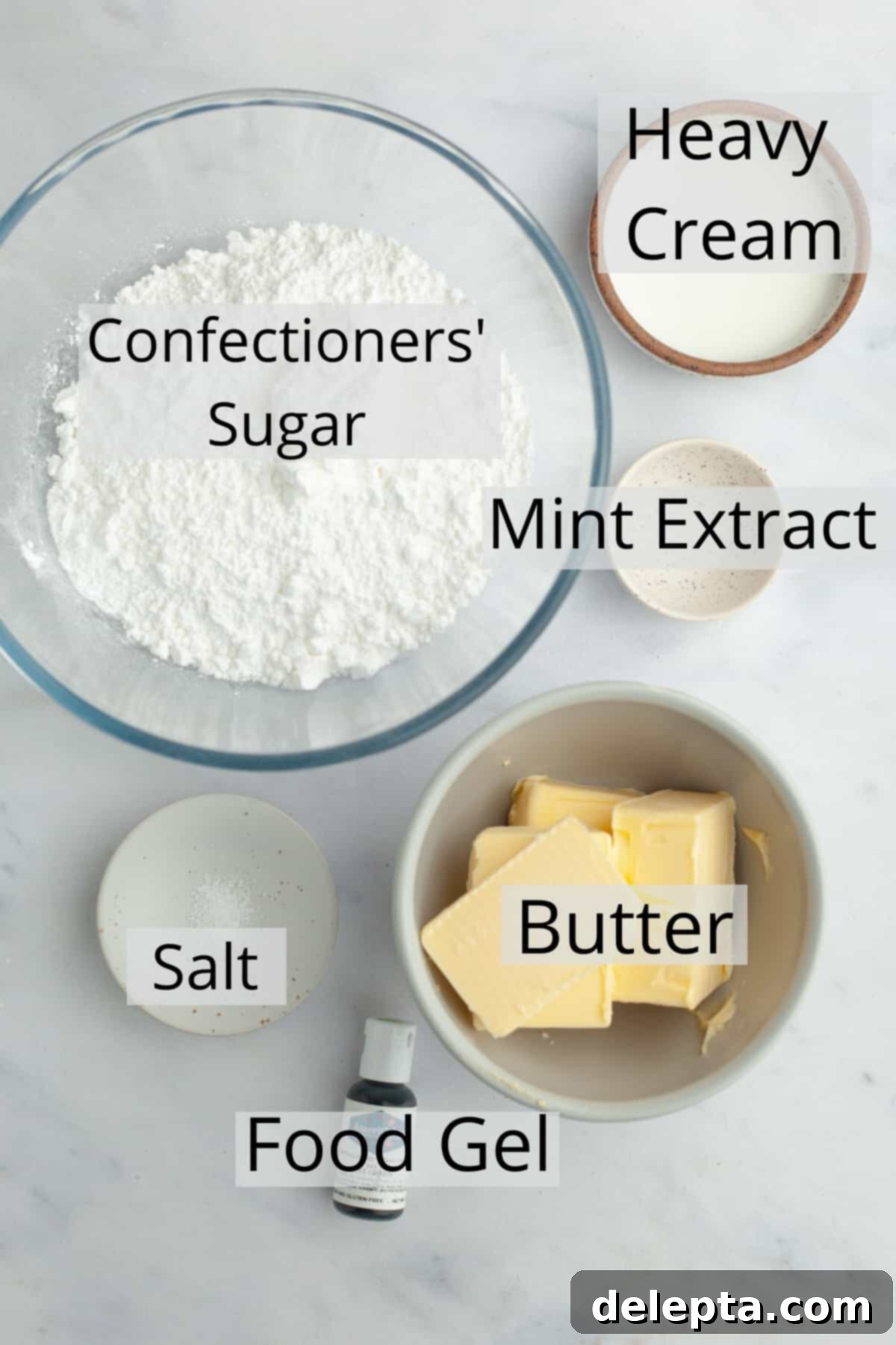 Effortless Five Minute Mint Frosting 3 All the ingredients needed to make mint frosting, weighed out into small bowls, including butter, powdered sugar, cream, mint extract, and green food coloring.