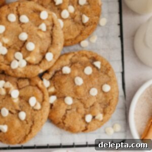 Soft-Baked Pumpkin White Chocolate Chip Delights 9 Pumpkin cookies with white chocolate chips on parchment paper.