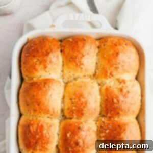 Irresistibly Soft and Fluffy Garlic Dinner Rolls 11 Baked garlic dinner rolls in a white baking dish, ready to be served.
