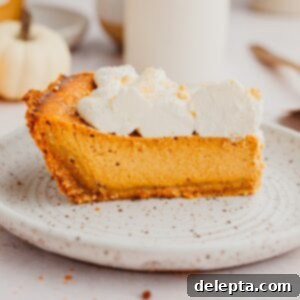 Graham Cracker Crust Pumpkin Pie 10 A slice of pumpkin pie topped with whipped cream.