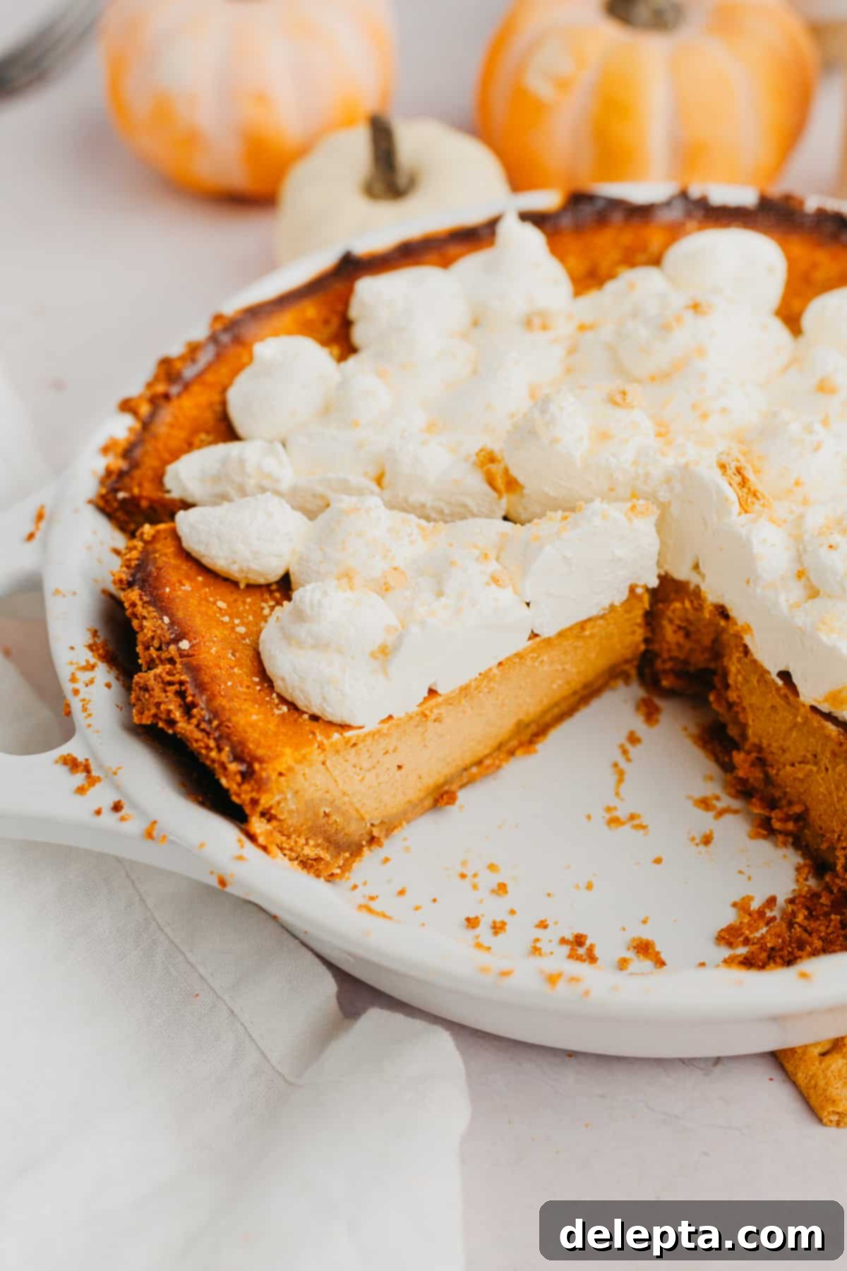 Graham Cracker Crust Pumpkin Pie 8 A pumpkin pie with graham cracker crust and topped with whipped cream.