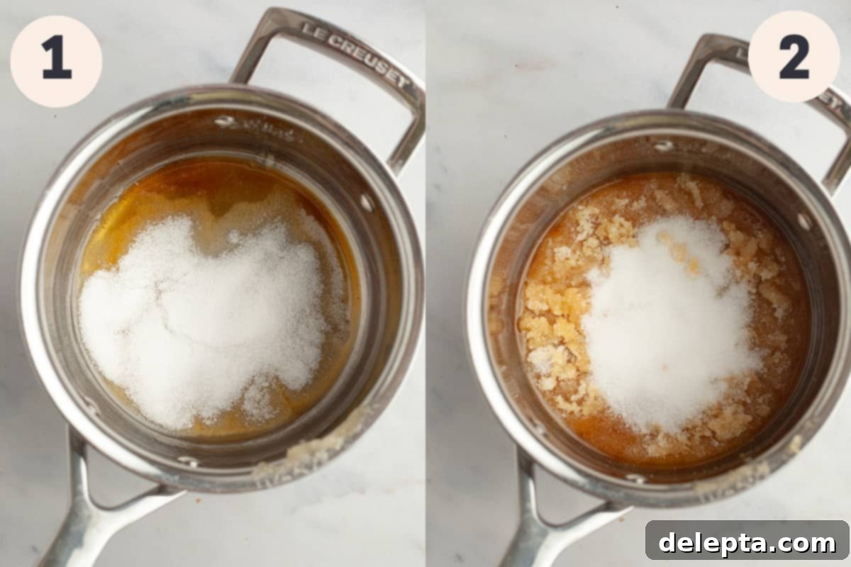 Decadent Homemade Salted Caramel Sauce 4 A silver saucepan containing granulated sugar, just beginning to melt and transform into caramel on the stovetop.