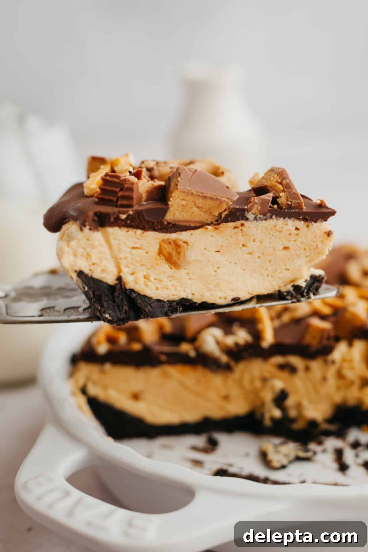 Decadent No-Bake Oreo Peanut Butter Pie 8 A silver cake server delicately lifts a perfectly portioned slice of Oreo peanut butter pie, showcasing its rich, layered texture.
