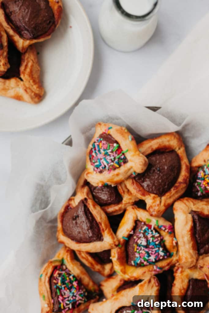 Purim Chocolate Pockets 8 Overhead view of chocolate and sprinkle hamantaschen, with a small bottle of milk for serving