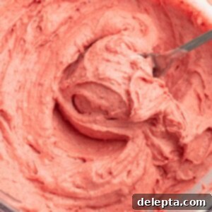 Dreamy Strawberry Cream Cheese Frosting 6 Strawberry frosting with a spoon.