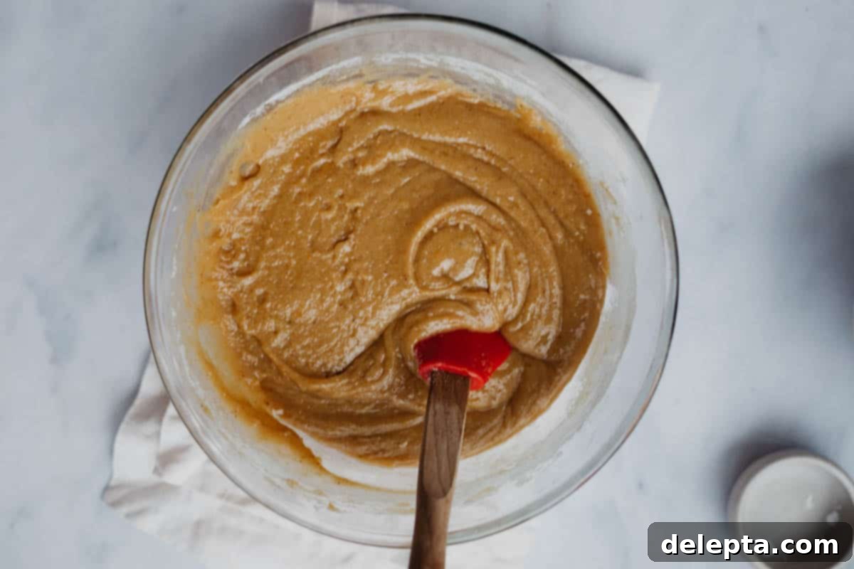 Sprinkle-Studded Golden Oreo Gooey Bars 7 Smooth blondie batter in a clear pyrex mixing bowl, showing the perfectly combined consistency.