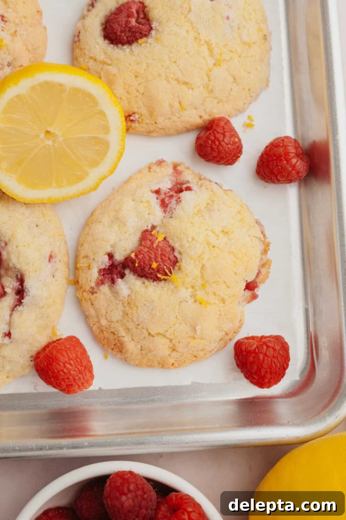 Easy One Bowl Lemon Raspberry Cookies 11 Lemon raspberry cookies on parchment paper, fresh out of the oven.