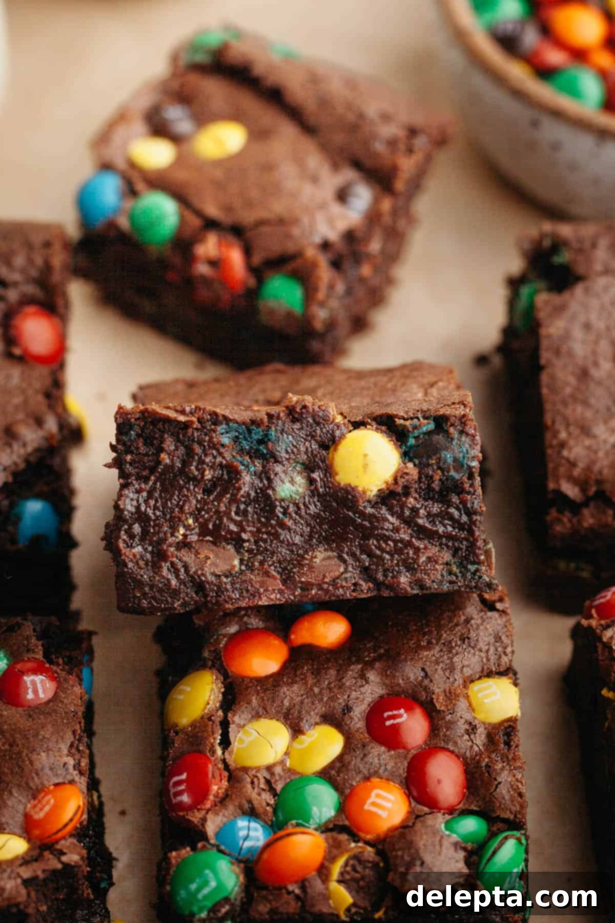 Fudgy M and M Brownies 11 M&M brownies on parchment paper.