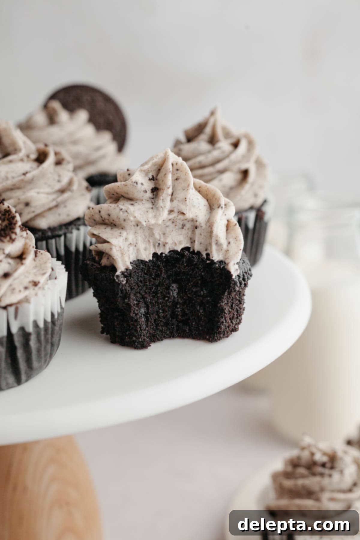 Decadent Chocolate Oreo Delights 2 A chocolate cupcake with Oreo frosting with a bite taken out of it, revealing a hidden Oreo at the bottom.