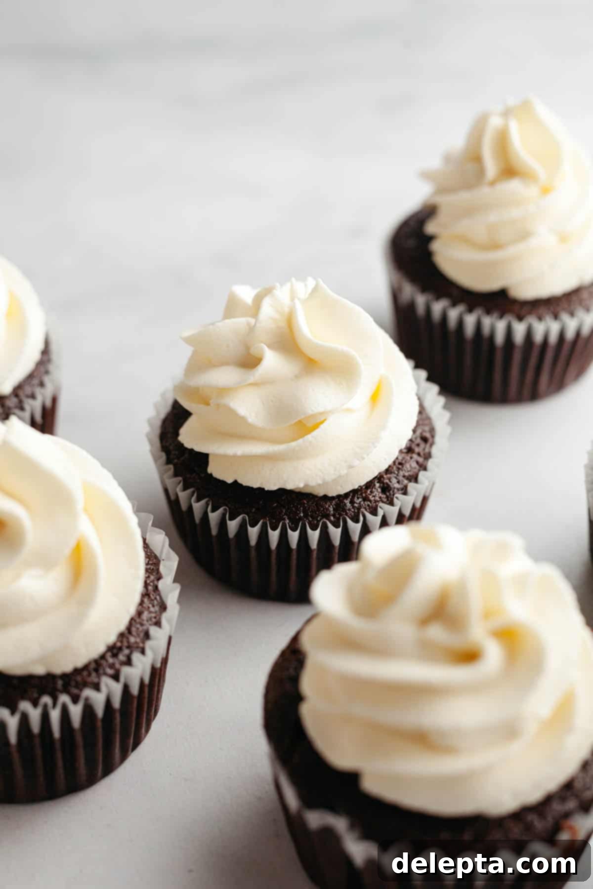 Perfect Butter-Free Cream Cheese Frosting in Minutes 2 Cream cheese frosting piped onto chocolate cupcakes, showcasing its smooth and stable texture.