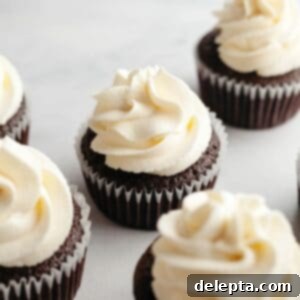 Perfect Butter-Free Cream Cheese Frosting in Minutes 8 Cream cheese frosting piped onto chocolate cupcakes, highlighting its smooth texture.