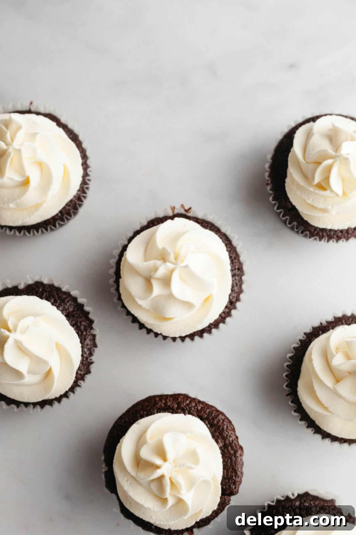 Perfect Butter-Free Cream Cheese Frosting in Minutes 6 Cream cheese frosting generously piped onto chocolate cupcakes, adorned with colorful sprinkles.