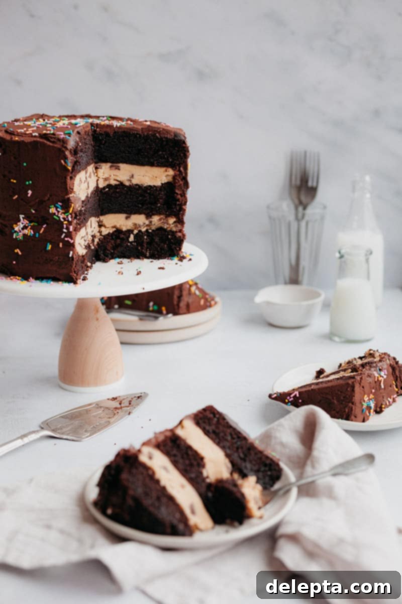 Chocolate Brownie Cookie Dough Fudge Cake 2 Chocolate cake on a cake stand with three slices on small plates