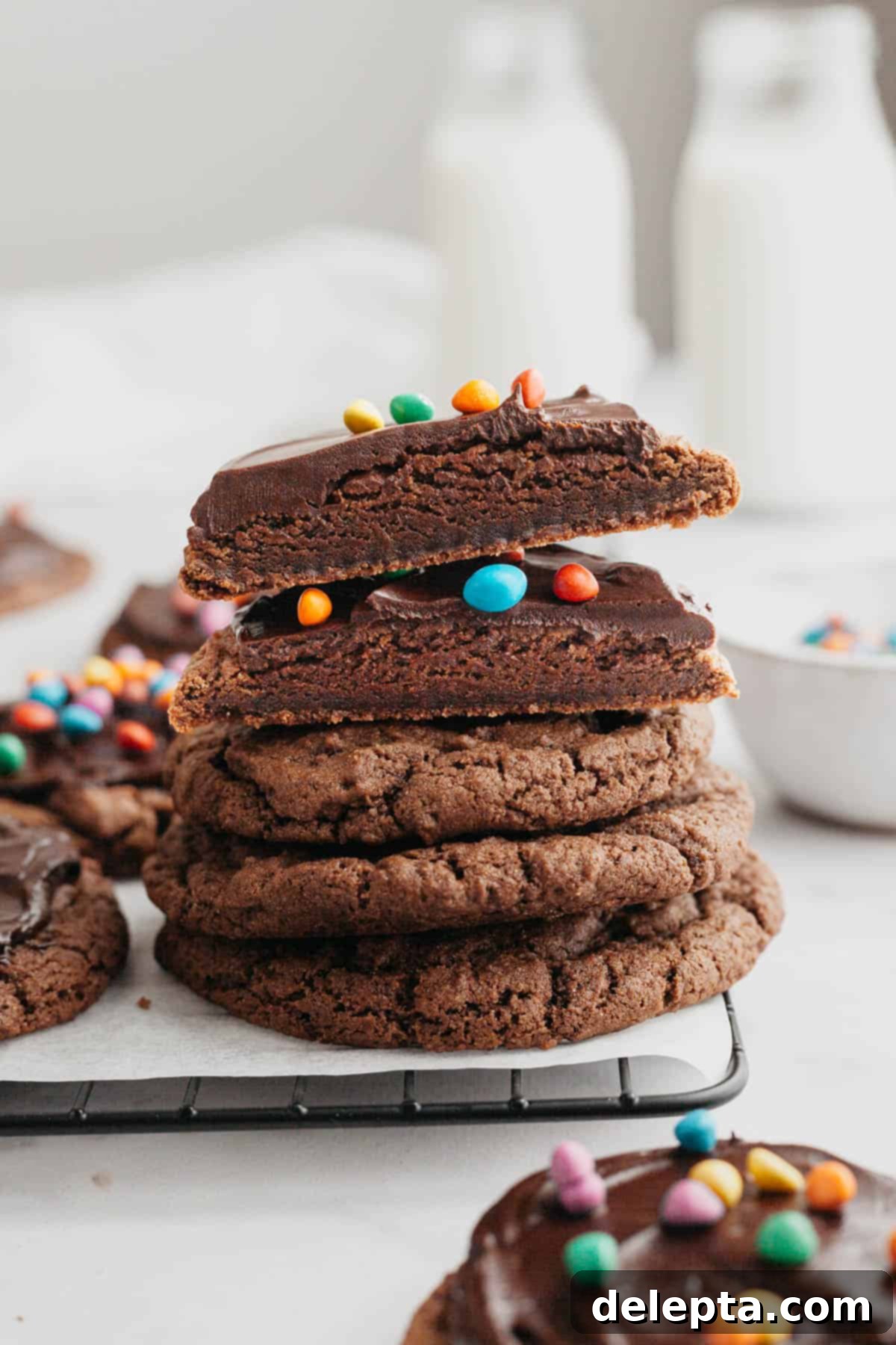 Galaxy Brownie Cookies 11 A delightful stack of finished cosmic brownie cookies, with one cookie cut in half to show its rich, fudgy interior.