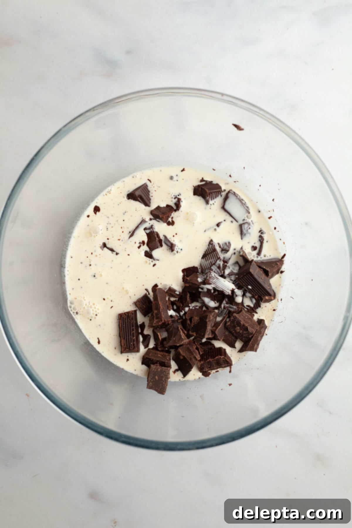 Galaxy Brownie Cookies 8 A large bowl containing chopped semi-sweet chocolate, with heavy cream being prepared.