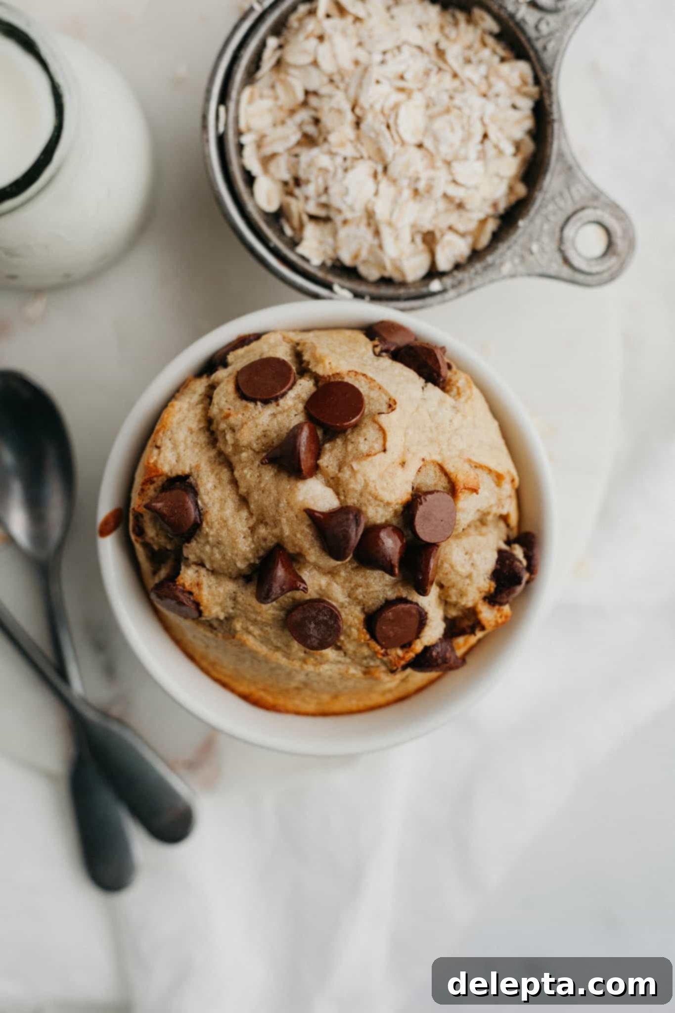 Single-Serve Baked Oat Indulgence 5 Baked oats covered in chocolate chips in a small white ramekin, ready to eat.