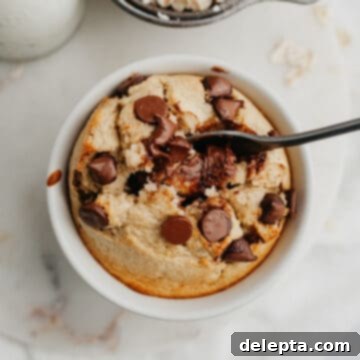 Single-Serve Baked Oat Indulgence 6 A small white ramekin with baked oats, there is a small spoon inside.