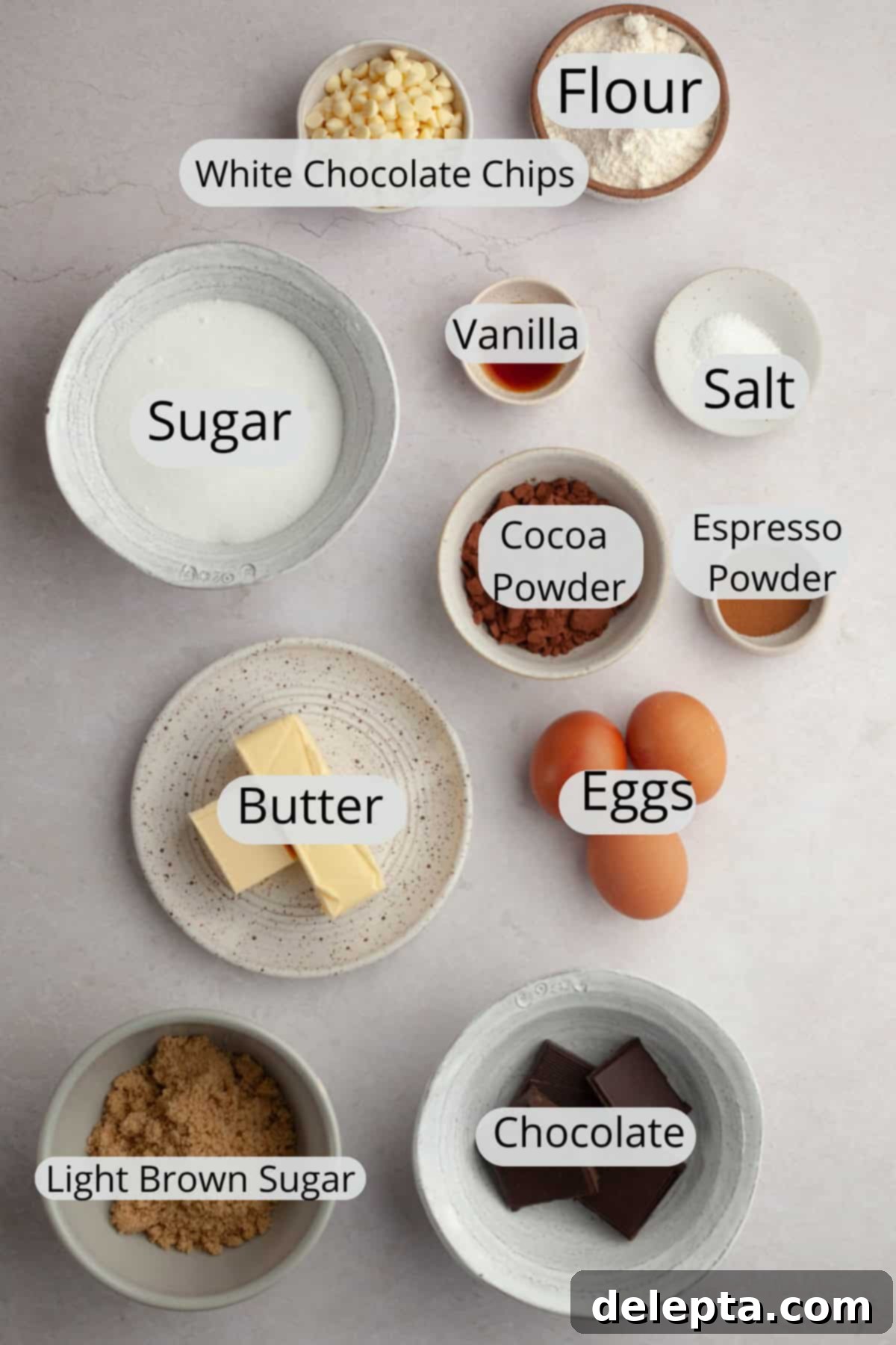 Effortlessly Fudgy White Chocolate Chip Brownies 3 A flat lay photograph displaying all the measured ingredients for making white chocolate chip brownies, neatly arranged in small bowls.