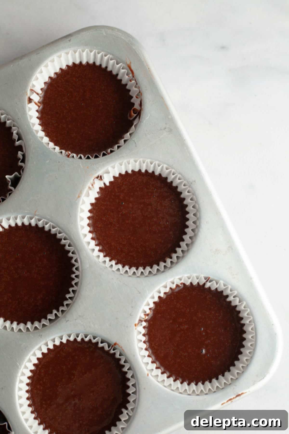 Decadent Chocolate Cream Cheese Cupcakes 7 Unbaked chocolate cupcakes in a cupcake pan, ready for the oven.