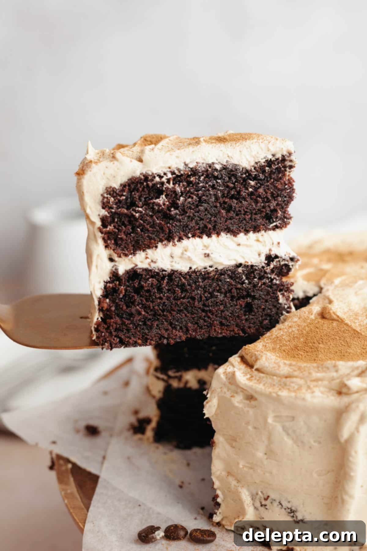 Simple Mocha Delight 2 A slice of rich coffee chocolate cake with creamy coffee frosting being lifted up with a cake server, ready to be enjoyed.