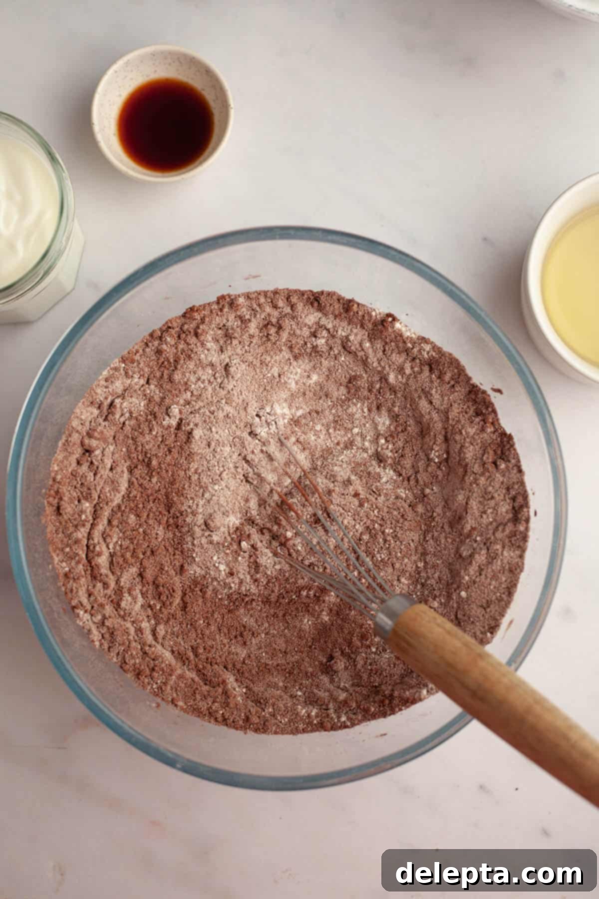 Simple Mocha Delight 4 A large bowl containing flour and cocoa powder, with a whisk resting inside, ready for mixing dry ingredients.