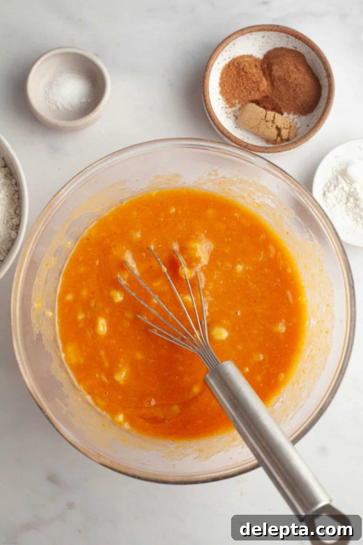 Effortlessly Moist Pumpkin Banana Muffins 4 Pumpkin banana muffin mixture in a bowl with a whisk.