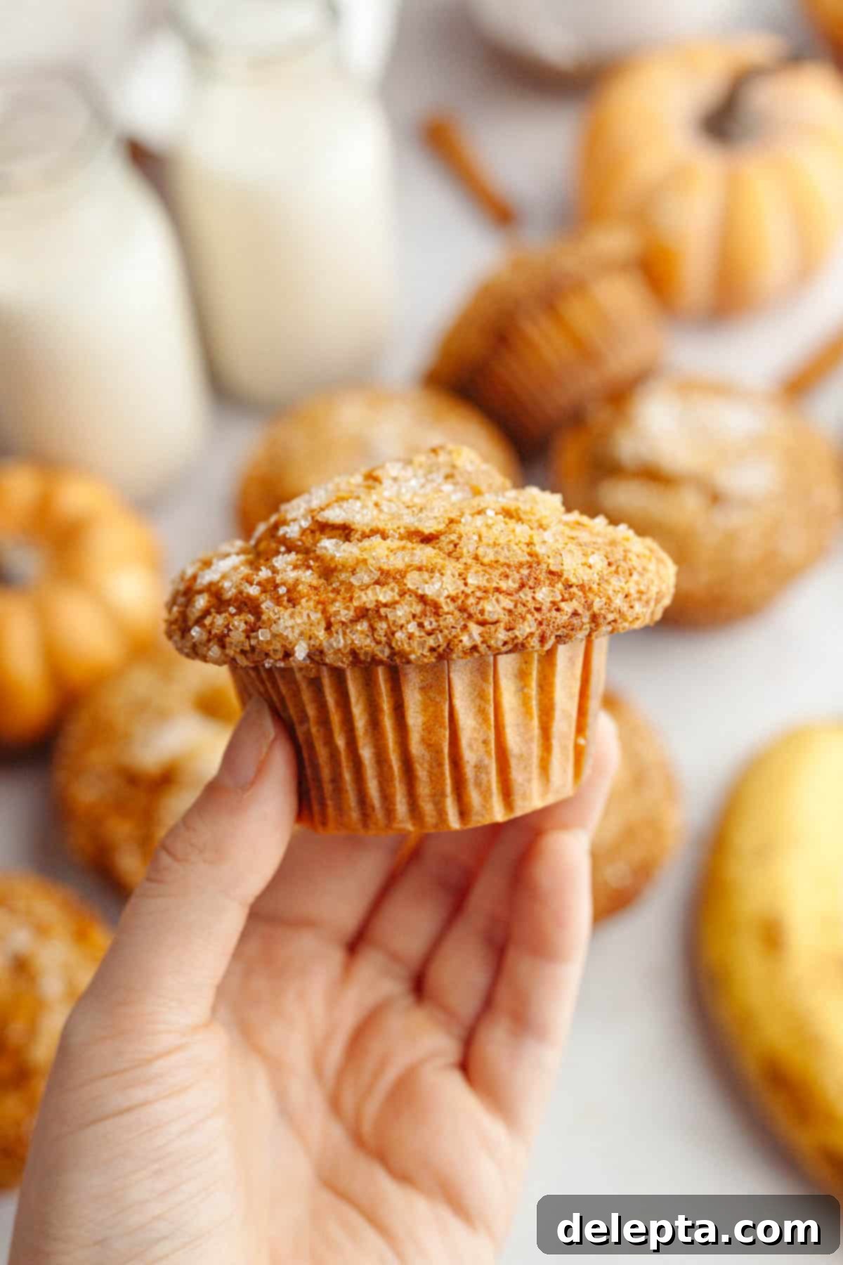 Effortlessly Moist Pumpkin Banana Muffins 9 A hand holding a pumpkin banana muffin.