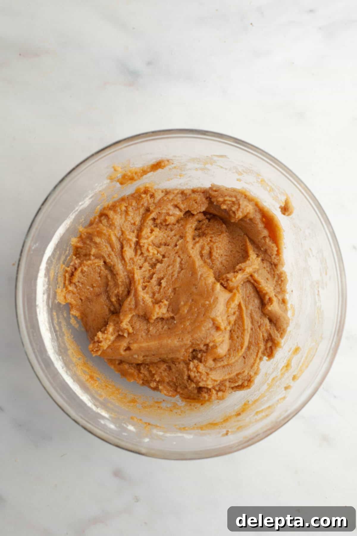 Ultimate Soft and Chewy Pumpkin Cookies 7 Beige cookie dough in a bowl, after dry ingredients have been incorporated.